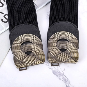 Women's black elastic wide waist belt with vintage bronze geometric buckle on marble