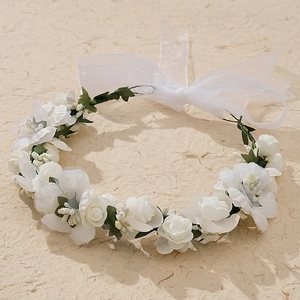 Détail d'une couronne de mariée en fleurs blanches en tissu avec ruban transparent