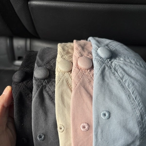 Detail view of cotton twill baseball caps showing top buttons and ventilation eyelets