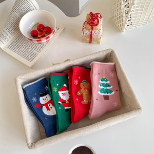 Set of 4 Christmas crew socks featuring snowman and Santa Claus motifs in a gift box