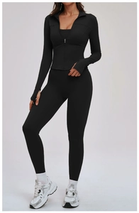 Détail de la veste de yoga noire ajustée avec fermeture éclair et passants de pouce