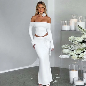 Detail of elegant white two-piece set with long sleeve crop top and fishtail skirt