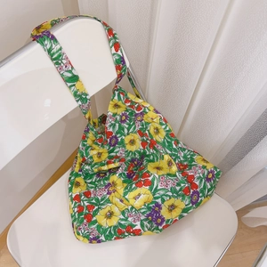 Detail of floral cotton tote bag with strawberry print hanging on a white chair