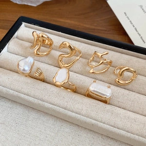 French vintage style gold rings set with baroque pearls displayed in a beige jewelry box