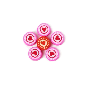 Detailed view of heart-patterned polymer clay beads arranged in a flower shape for DIY jewelry