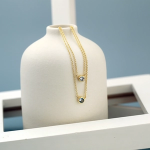 Double layered gold necklace with round light and dark blue gemstone pendants