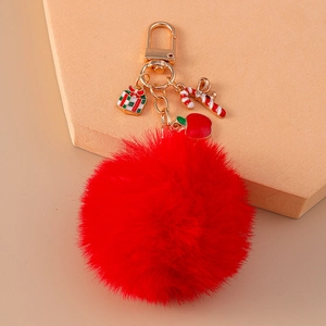 Close-up of red faux rabbit fur pompom keychain with festive Christmas charms and gold ring