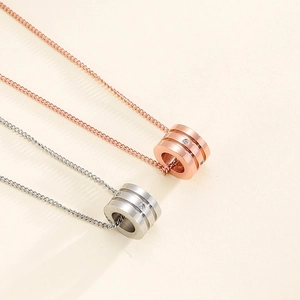 Detail of rose gold and silver cylinder pendants with sparkling embedded crystals
