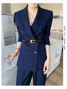 Detail of slim black leather belt with gold U-buckle on a navy blue double-breasted suit