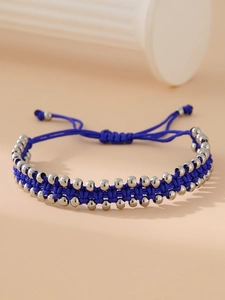 Détail du bracelet tressé à la main bleu marine avec perles en acier argenté poli