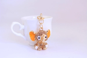 Detailed macro view of golden elephant keychain with sparkling rhinestones and orange enamel