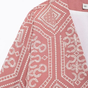 Pink oversized kimono cardigan featuring white geometric embroidery and textured fabric