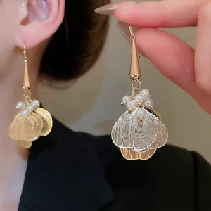 Elegant hollow petal earrings with pearls and golden tassels for a stylish women's look
