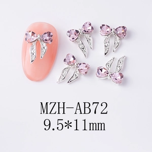 Vue macro d'un bijou d'ongle nœud 9,5x11mm avec cristaux de cœur rose et rubans argentés