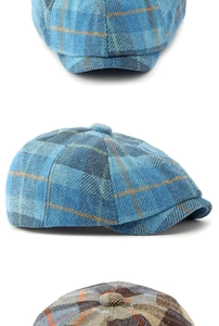 Detail view of newsboy caps in blue and grey plaid wool texture with 8-panel design