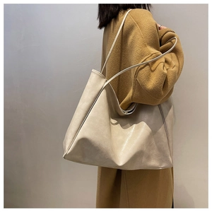 Minimalist beige PU leather tote bag worn over the shoulder showing large capacity