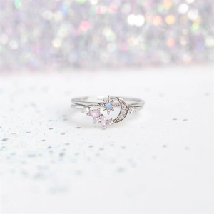 Star and moon ring in silver with purple gemstones and zircons on a bokeh background