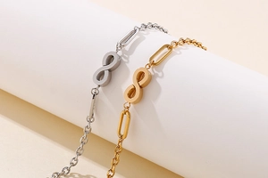 Detail showing infinity symbol charm on sleek gold and silver plated chain bracelets
