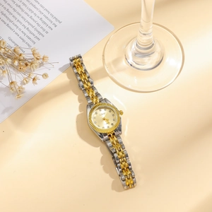 Élégante montre quartz dorée pour femme avec index en cristal sur un fond lifestyle chaud
