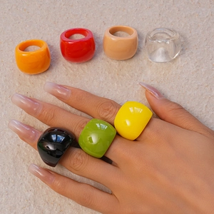 Collection of thick colorful resin rings in various vibrant candy tones on stone base