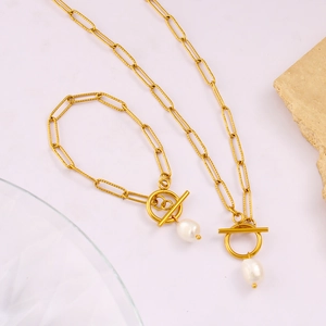 Dettagli del set collana e bracciale a maglie dorate con perla e chiusura a levetta