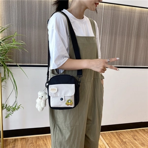 Détail du sac bandoulière en toile avec pendentif ours blanc et sangle réglable sur modèle