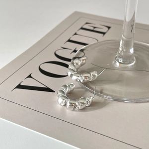 Minimalist 925 sterling silver twisted hoop earrings with a matte satin finish on Vogue magazine