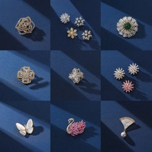Collection of gold and silver brooches with floral and animal motifs on blue velvet