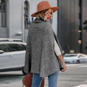 Dettaglio di un poncho grigio a maglia grossa con collo alto e trama spessa in stile urbano