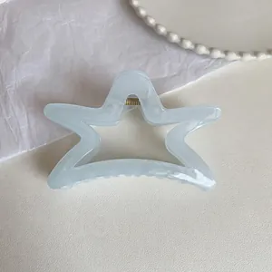 Detail view of the star-shaped light blue hair claw with durable gold metal spring