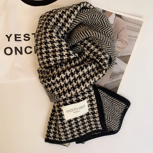 Classic black and white houndstooth knitted winter scarf with soft wool-like texture