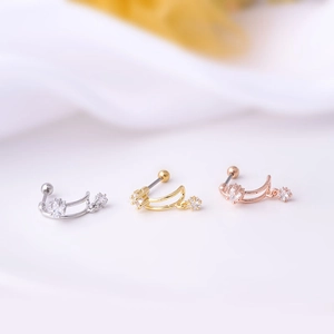 Three half-hoop ear studs with star pendants and screw backs on white fabric