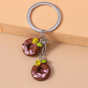 Close-up of chocolate donut keychains with pink floral patterns and yellow rose details