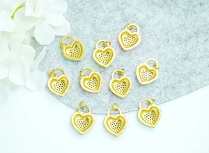 Ten golden heart charms with mesh grid hollow design on a grey felt background