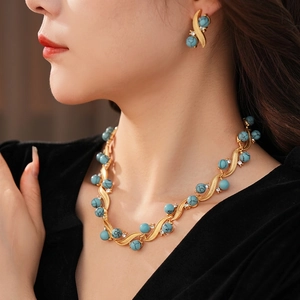 Vintage gold jewelry set with turquoise beads and crystal accents on a female model
