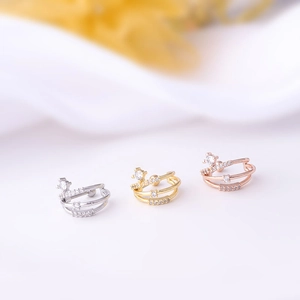 Detailed view of three semicircular stainless steel earrings in silver, gold, and rose gold