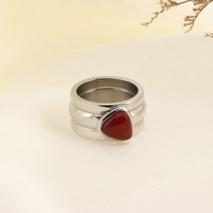 Detail of silver irregular ring with embedded red stone and textured metal finish