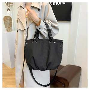 Detail of large black canvas work bag shown in a lifestyle setting with natural lighting