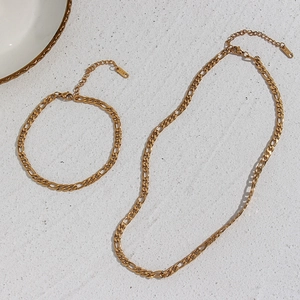 Close-up of 18K gold plated Figaro chain necklace and bracelet with K18 engraving