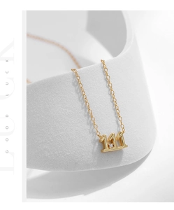 Macro view of gold 111 number pendant necklace with sparkling diamond on a white stand