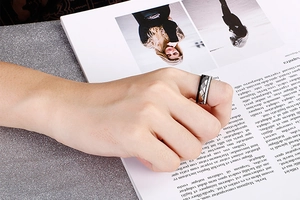 Detail of two-tone stainless steel ring with black texture and sparkling diamond accents
