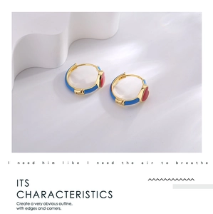 Detail of heart-shaped earrings with blue enamel and red heart on gold plating