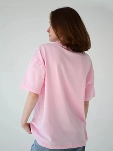 Πίσω όψη ενός casual ροζ βαμβακερού T-shirt με κοντό μανίκι σε μοντέλο με φόντο