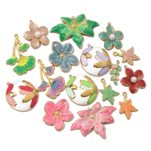 Detail of colorful enamel flower and leaf pendants with pearls for jewelry making