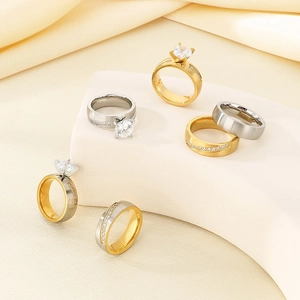Close-up of gold and silver four-claw diamond rings on a luxury satin display