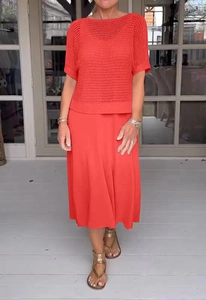 Dettaglio del set due pezzi in maglia rossa con top a girocollo e gonna midi