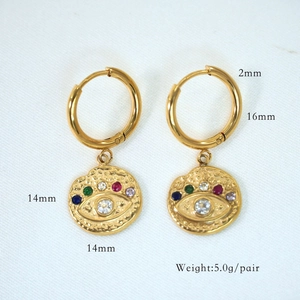 Detailed view of gold hoop earrings with evil eye charms and colorful zircon accents