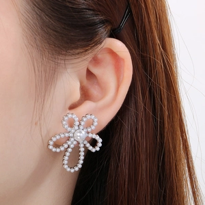 Close-up of pearl flower earrings on model showing size and elegant petal details