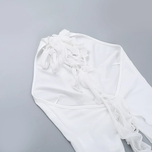 Detailed view of elegant white ruffles and pleats on the halter neck beach top fabric