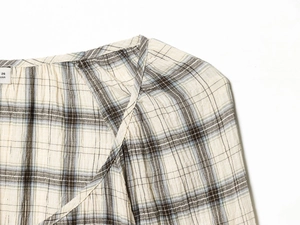 Dettaglio della spalla e del motivo a quadri su un set di camicia in cotone lino